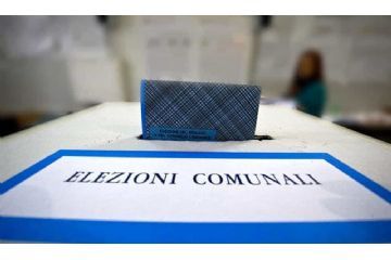 Si rappresenta un'urna elettorale, dove viene inserita una scheda elettorale. La scritta indica "ELEZIONI COMUNALI".